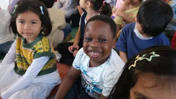 Young AITIS students smiling in class