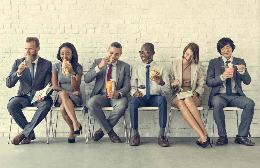 workers eating lunch on bench