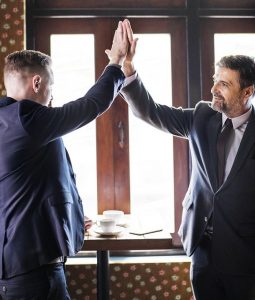 Two business men closing a deal and celebrating.