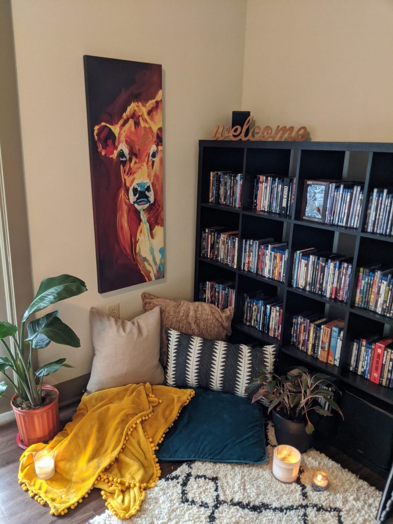 calm corner with cow and bookshelf and pillows on the floor