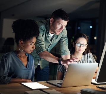 3 people looking at a laptop